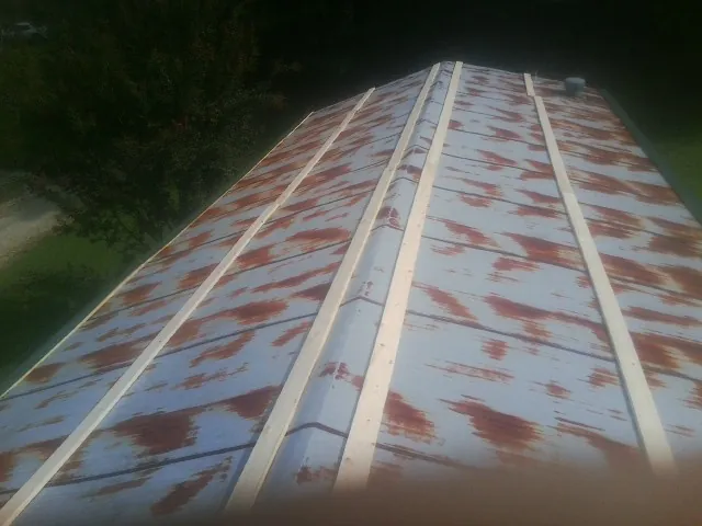 Rusted metal roof panels with new wood purlins before replacement — Storm Damage Roof Repair in Durhamville by Roofing Brothers